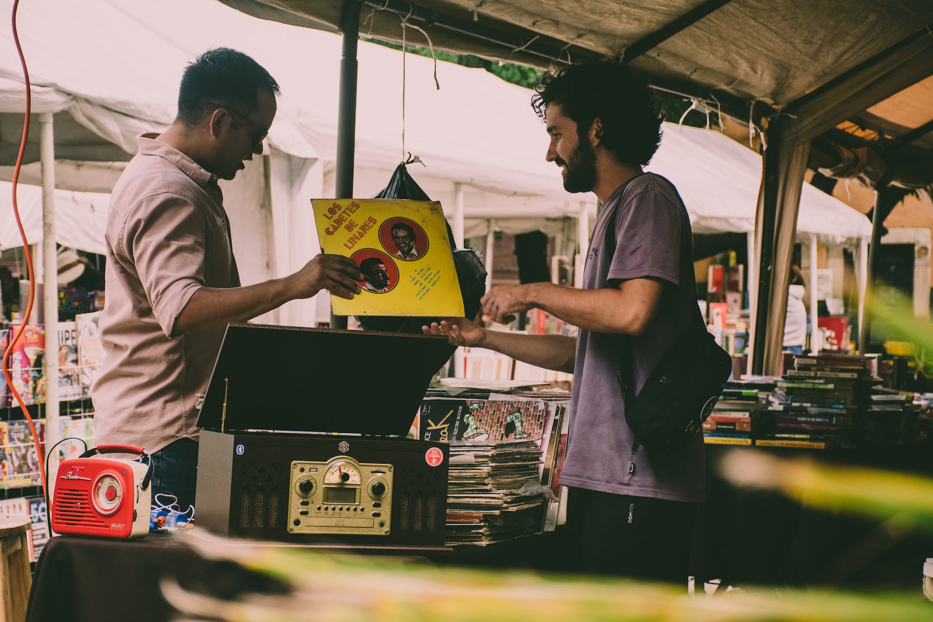 photo of a man selling vinyl records under a tent