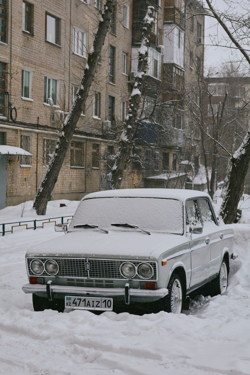snow covered vintage car on urban winter street