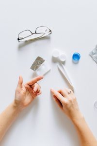 person putting contact lens on fingers