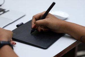 a person using a graphic tablet and a pen