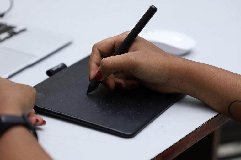 a person using a graphic tablet and a pen